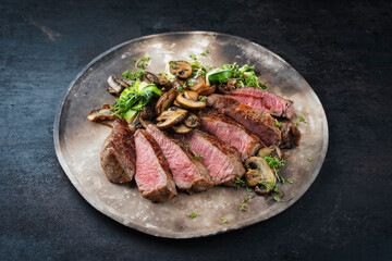 Traditional barbecue grass-fed dry aged roast beef steak  with mushrooms and greens