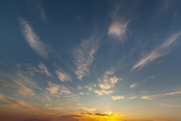 Vibrant sunset sky filled with wispy clouds reveals a colorful horizon at dusk