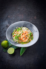 Authentical Asia style ramen noodle soup with prawns and cashew nuts served as close-up in a design bowl with copy space