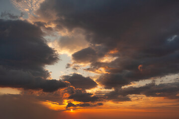Sunset over a cloudy sky with vibrant colors illuminating the horizon at dusk