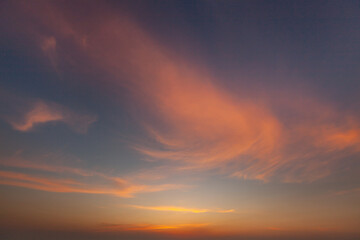 Beautiful sunset over a serene landscape with colorful clouds and fading daylight