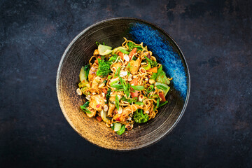 Authentical Thai mie goreng spicy stir-fried noodles with chicken and vegetables served as top view...