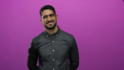 Obraz premium Man smiling confidently against a vibrant pink background in a portrait with glasses and dark hair wearing a casual shirt creating a stylish and modern composition