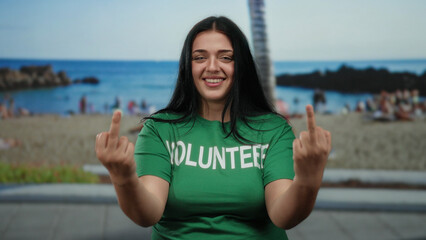 Woman in green volunteer shirt by seaside beach scene showing middle finger gesture curvy dynamic...
