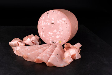Traditional Italian artisan handcrafted fine mortadella with pistachio and truffle offered as close-up on design black board with copy space © HLPhoto