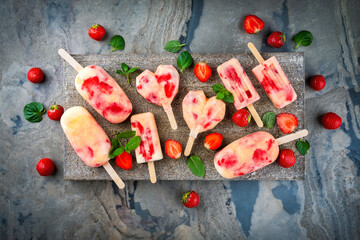 Frozen dessert - homemade strawberry ice lolly popsicle  with yogurt, fresh strawberries in heart...