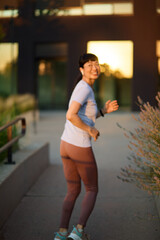 Portrait of a young beautiful sport woman smiling happy and confident. Running   in city park...