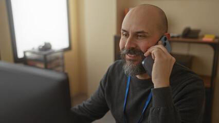 Man talking phone office workplace indoor bald beard casual caucasian professional happy...