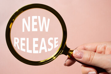 New Release symbol. Concept word New Release on magnifying glass. Beautiful pink background....