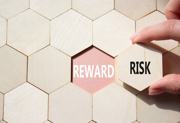 Risk or Reward symbol. Concept word Risk or Reward on wooden comb puzzle. Businessman hand....