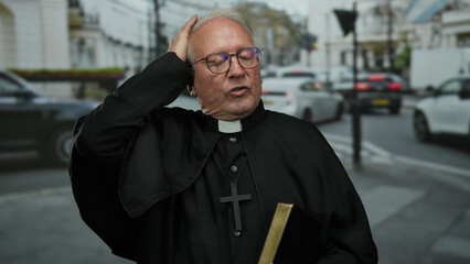 Senior priest man holding a book in a busy street setting while expressing contemplation with...