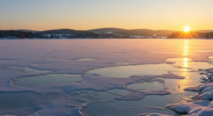 Serene winter sunset over a frozen lake, with patches of open water reflecting the warm light
