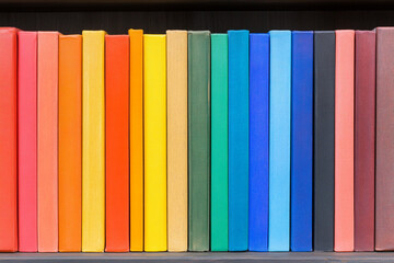 Rainbow books on a shelf create colorful chaos