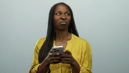 Woman texting on smartphone appearing frustrated against isolated white background showing adult...