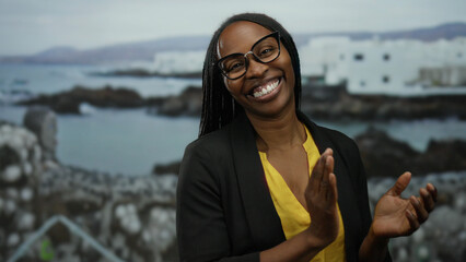 Woman smiling with curly hair on seaside promenade at beach with scenic sea and buildings in...