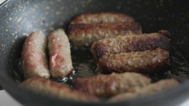 A balkan traditional meatball dish cevapi, cevapcici on wooden table in close-up	
