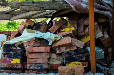 A pile of bricks and a white cloth. The bricks are stacked on top of each other and the cloth is on...