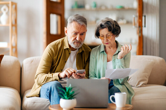 Stressed upset senior spouses checking financial papers, looking at loan documents, suffering crisis while calculating family spends - Powered by Adobe