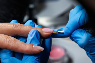 Manicure Process with Nail Brush and Gel Application, Closeup of professional manicurist applying...