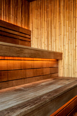Wooden sauna interior with bamboo walls and warm backlight under benches. Cozy and modern design of...
