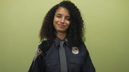Young hispanic woman police officer clutch chest gesture against a yellow wall in a studio;...