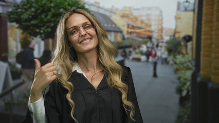 Woman smiling in judge uniform pointing upwards on a bustling street with buildings in the...