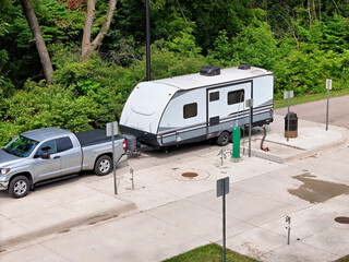 Travel trailer RV camper emptying waste tanks at a dump station
