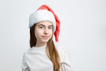 Cheerful little girl in Santa hat showing joy, delight, surprise, approval. Happy emotions, joy of...