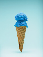 Double scoop blue bubble gum ice cream cone isolated on blue background