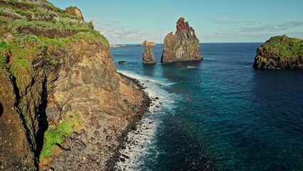 Naklejka premium Bird's-eye view of the rocks sticking out of the water. Rocks on the shore. Daylight