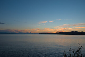 Fototapeta premium Serene Lake Taupo at dusk, with soft pastel hues reflecting on the calm water, capturing a peaceful and expansive natural beauty.