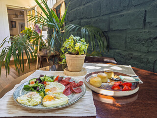Cozy cafe setting with vibrant breakfast of eggs fresh salad meat slices and sweet pancakes