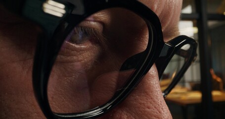 The man is concentrating on working in the office. The video moves from a close-up of his eyes to a...