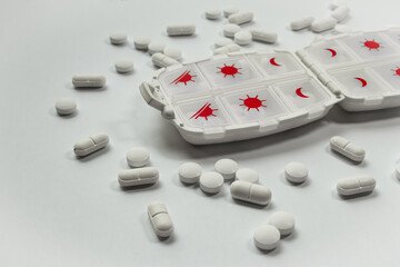 White pill box in a circle of pills, daily medication, taking vitamins