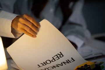 Late Night Review. Close-up of hand flipping through financial report.