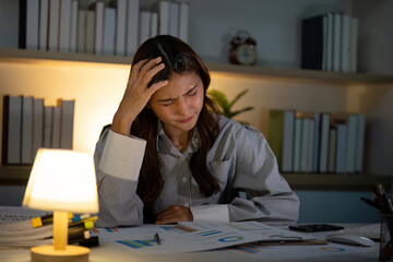 Late Night Stress. Woman showing frustration while working on financial analysis.