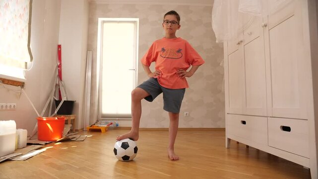 Child posing with soccer ball in renovated room