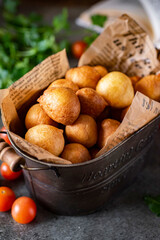 Small donuts in a beautiful vase on a gray table. Sweet donuts for breakfast. Vertical photo. Close-up