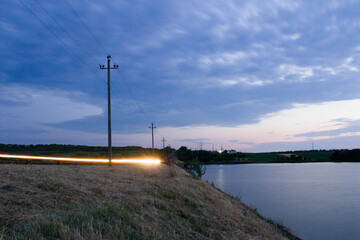 A body of water with power lines on it and a sunset in the background