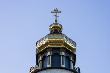 Historic church dome featuring intricate designs and a prominent cross shines brightly in the...