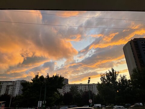 Fiery sunset sky with dramatic clouds and silhouetted trees