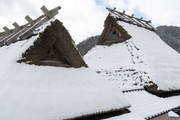 雪が積もっている茅葺き屋根