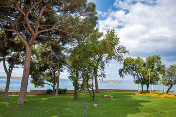 Green park with sea view and lighthouse in Porec, Istria, Croatia.