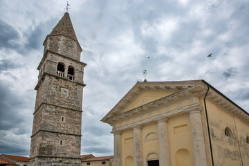 Historic bell tower and church with dramatic sky. Visnjan, Croatia.