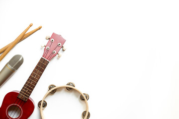Recording music in a studio. Musical instruments for band - small guitar, drumsticks and tambourine...