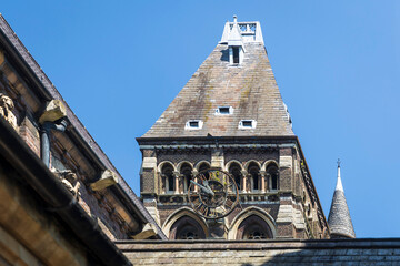 A Grand Clock Tower with a Steeple Rises Towards a Clear Blue Sky. Fragment of St Stephen's Church,...