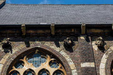 Detailed Stone Carvings of Angels Adorn the Brick Wall Above Arched Windows of a Historic.  Fragment of St Stephen's Church, Hampstead,  London, west entrance