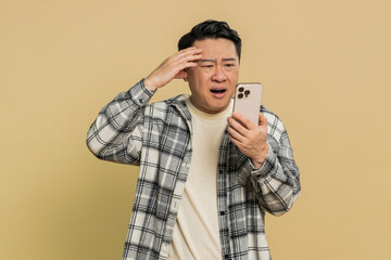 Upset sad Asian man use smartphone typing browsing, play game, loses, surprised by sudden lottery...