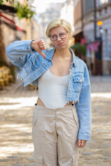 Dislike. Upset Caucasian young woman showing thumbs down sign gesture, expressing discontent...