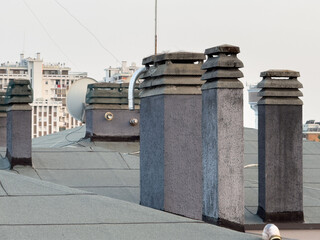 Mestre, Italy - June 25, 2025: Rooftop view showcasing multiple chimney stacks against a city...